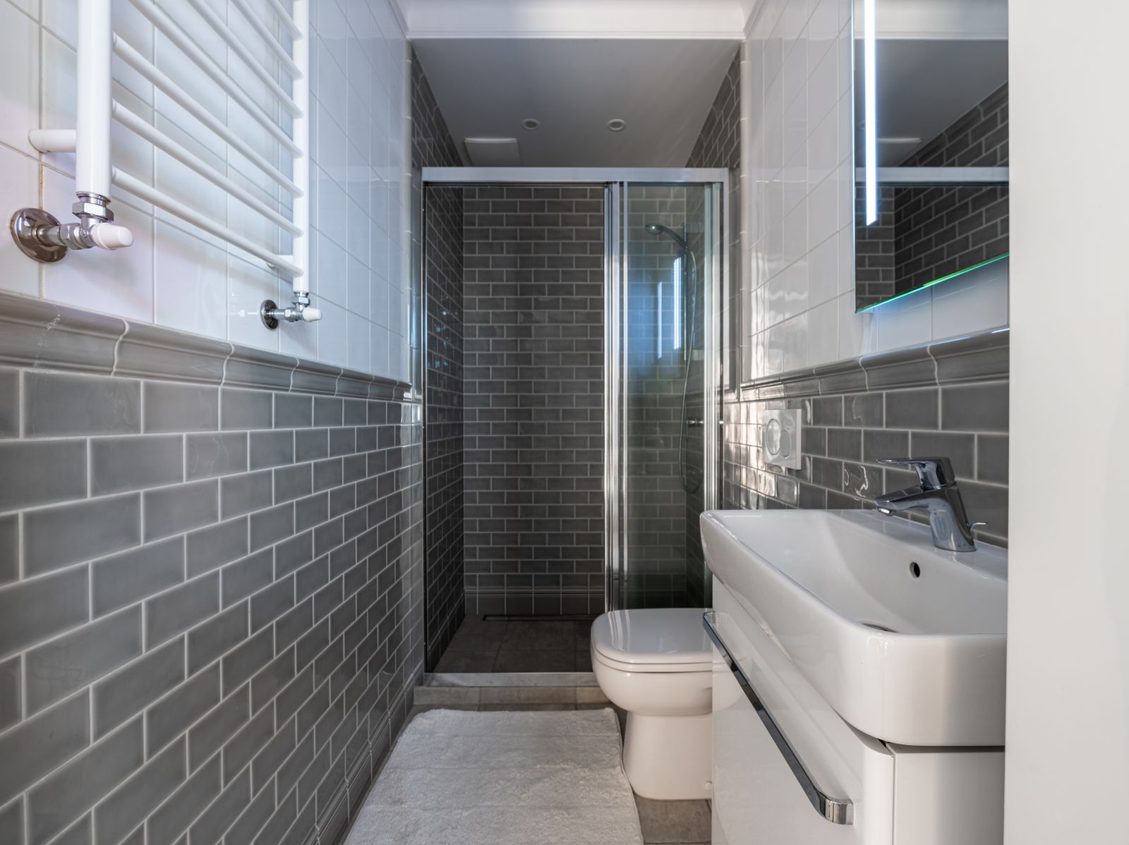 A tiled curbless shower entry finished flush with the bathroom floor